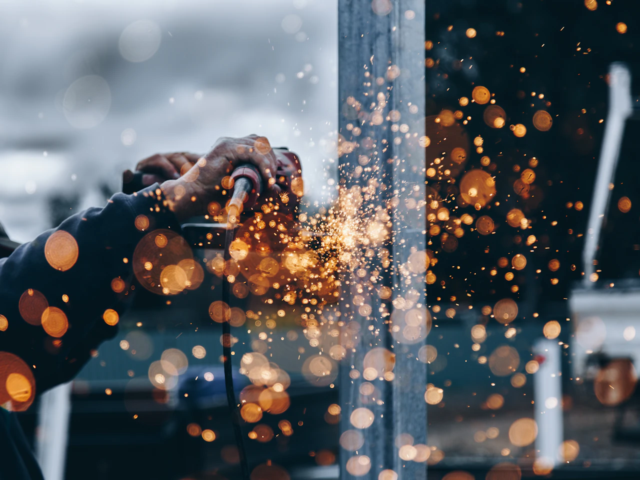 A craftsperson working with metal in a workshop.